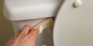 Closeup of a man flushing a toilet after using the bathroom