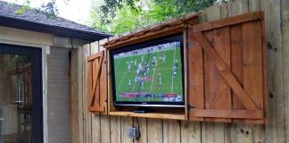 Outdoor TV cabinet, seen with the doors open as a football game plays on the screen