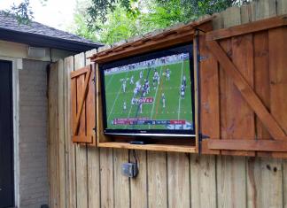 Outdoor TV cabinet, seen with the doors open as a football game plays on the screen