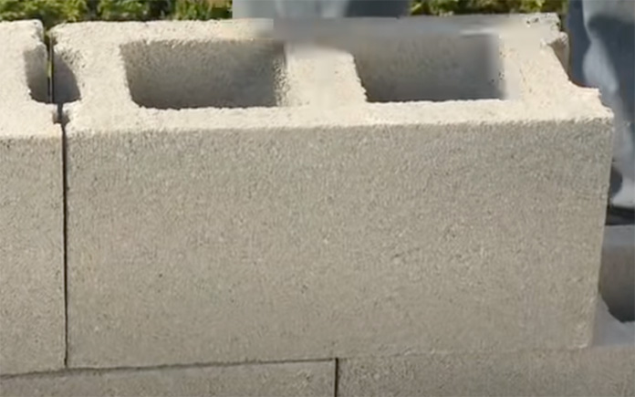 Dry-stacking the concrete blocks to form a wall