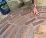 Brick patio with container of sealer.