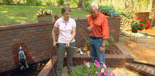 Julie Day and Danny Lipford watering plants