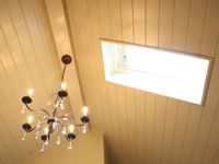Vaulted bathroom ceiling with skylight and chandelier.