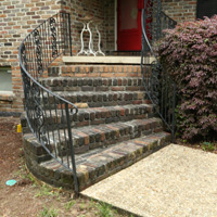 Brick steps with wrought iron railing.