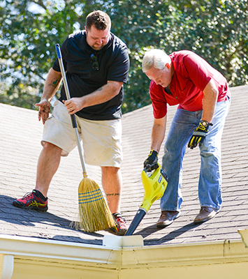 Chuck and Danny clean the roof and gutters.