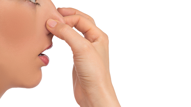 Woman holding her nose due to bad odor