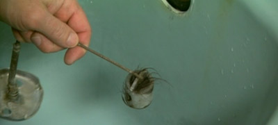 Cleaning hair and debris from drain bail.
