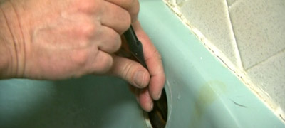 Inserting the drain stick in the drain.