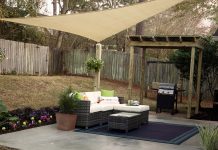 Upgraded patio with new furniture, shade sail, new flowers and resurfaced concrete