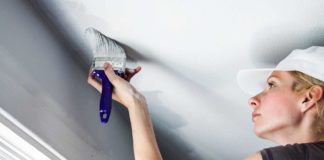 Woman Painting Popcorn Ceiling During Home Remodeling