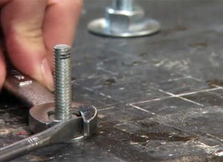 Joe Truini busts nuts loose with a wrench in his workshop.