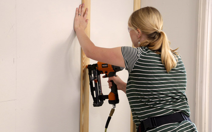 Chelsea Lipford Wolf nails vertical boards of accent wall into place