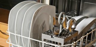 Dishes and flatware waiting to be washed in a dishwasher