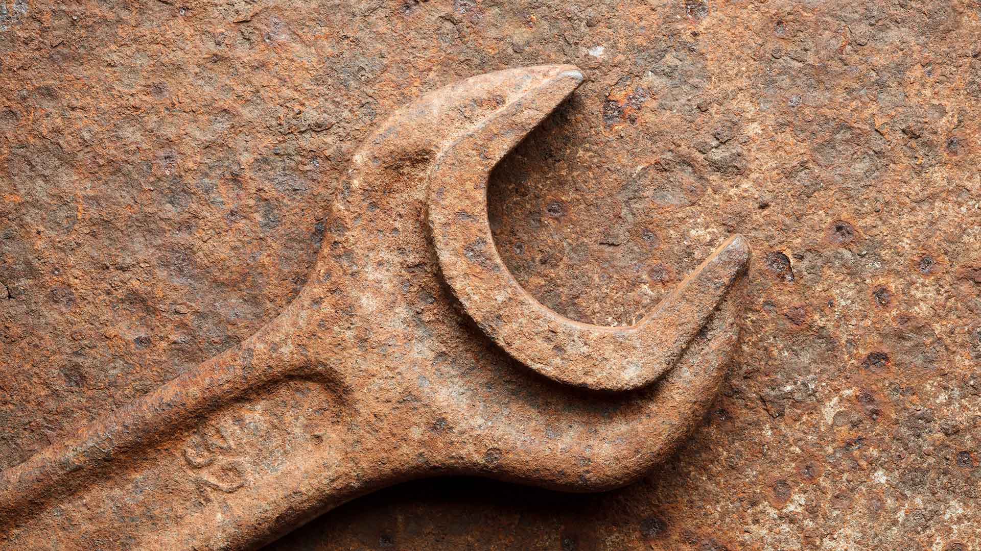 An eroded wrench with a lot of rust. 
