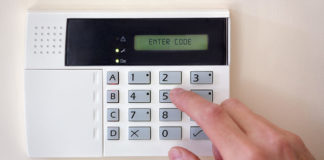 Finger pressing a key on a wireless home security system's keypad