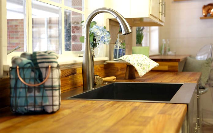 Butcher block countertop with modern kitchen faucet and apron sink