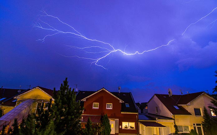 A lightning storm surrounds a suburban neighborhood