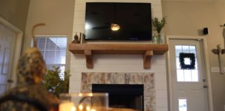 Faux shiplap fireplace with mantel and candle on accent table