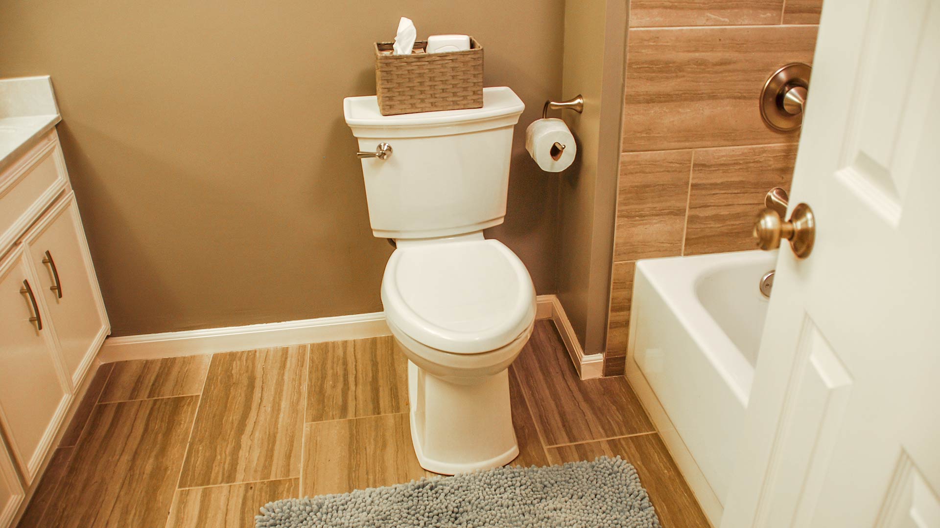 Bathroom with luxury vinyl flooring, a toilet and brown-painted walls. 