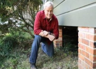 Danny Lipford next to crawlspace under house.