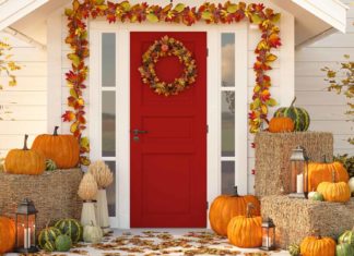 Exterior Thanksgiving décor featuring fall garland, pumpkins, bales of hay and pumpkins