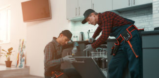 two repair men in kitchen