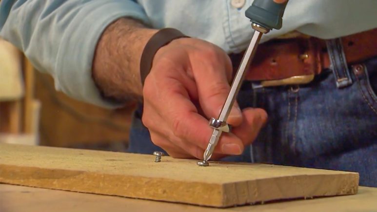 Joe Truini loosening screws with screwdriver and wrench