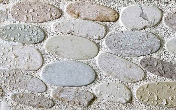 Grout between pebbles on a shower tile floor