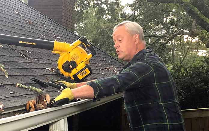 Danny Lipford removing leaves and other debris from a roof