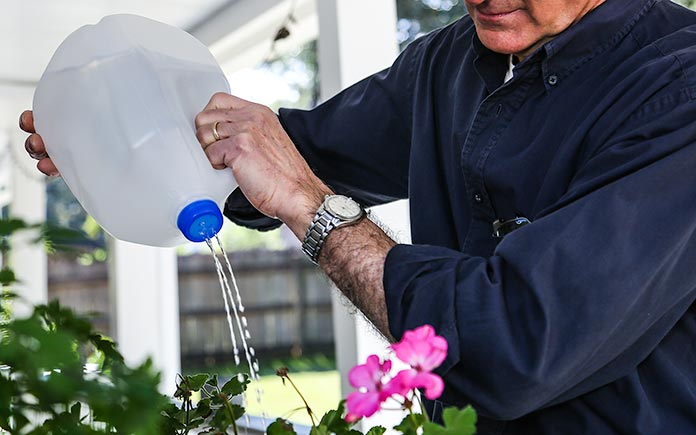 Upcycled water jug used as DIY sprinkler for watering plants