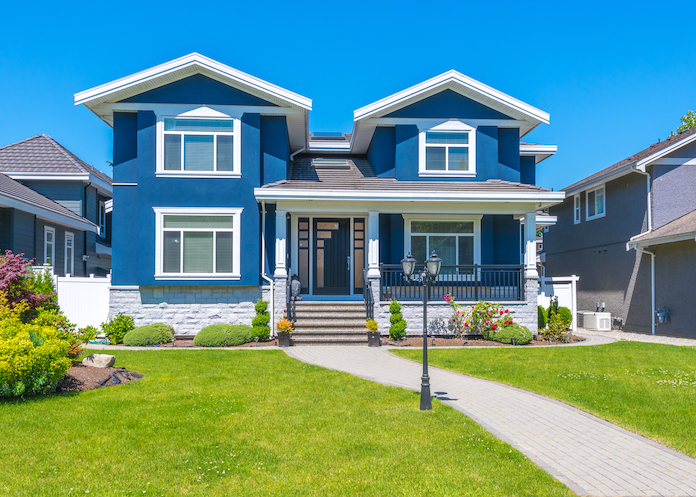 Big custom made luxury house with nicely trimmed and landscaped front yard in the suburb of Vancouver, Canada.