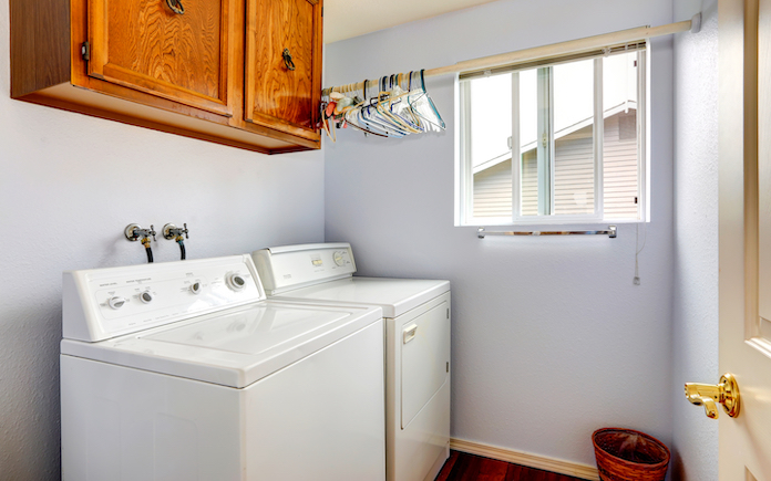 Simple laundry room with white appliances and wooden cabinet