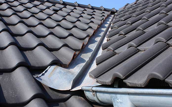 Closeup of roof valley, the seam between two sections of black metal roofing