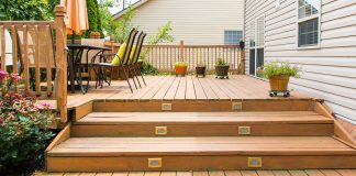 Deck stairs leading up to a townhouse with vinyl siding