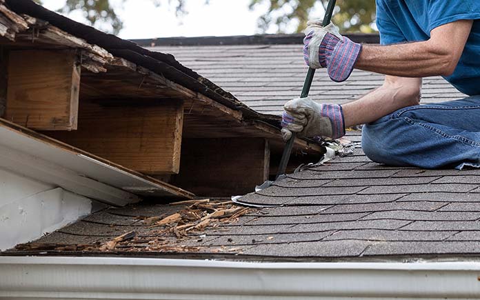 L'homme travaille sur un toit endommagé par la moisissure