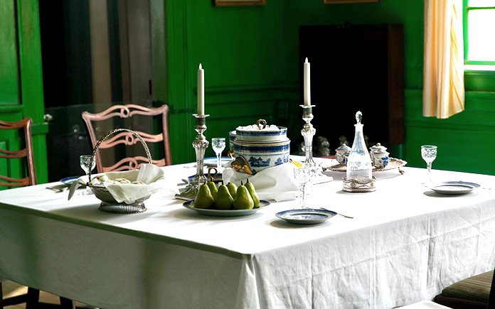 Green dining room featuring mid-century dining set and retro interior design