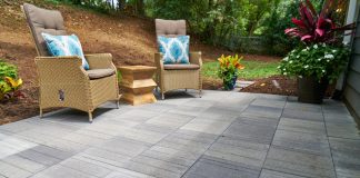 Wide view of Pavestone Avant Linear pavers on a patio with two lounge chairs.