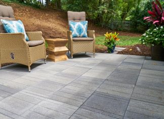 Wide view of Pavestone Avant Linear pavers on a patio with two lounge chairs.