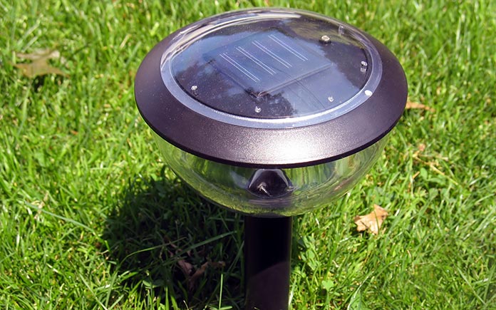Closeup of a solar-powered landscape light, as seen during the day in an eco-friendly backyard