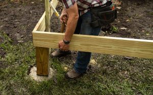 Danny Lipford installs wood deck post in concrete footing