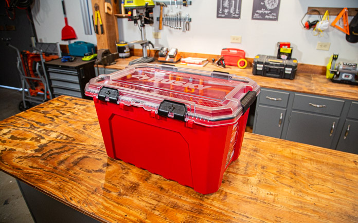 Husky's Professional-Duty Waterproof Storage Container, as pictured on a wood table in a workshop. 