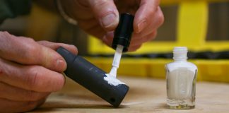 Joe Truini applies nail polish to tools in his workshop