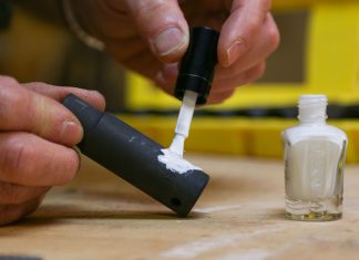 Joe Truini applies nail polish to tools in his workshop