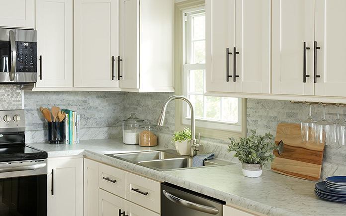 Armoires de cuisine blanches avec poignées modernes dans une cuisine mise à jour à partir de 2020