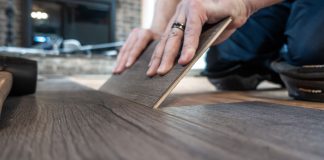 Closeup of man replacing a single plank of luxury vinyl flooring