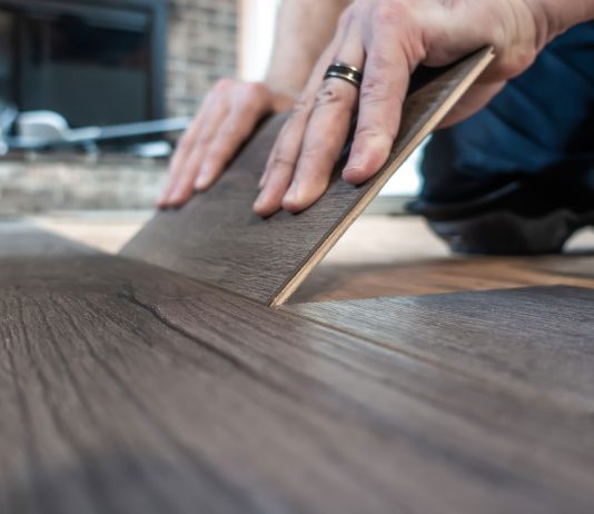 Closeup of man replacing a single plank of luxury vinyl flooring