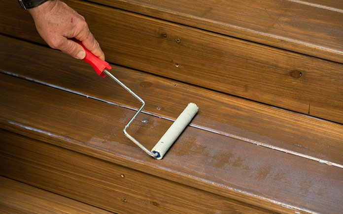 Rolling on TracSafe Anti-Slip Sealer with a paint roller