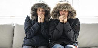 Couple, shivering cold, in home that has not heat during the chilly fall and winter