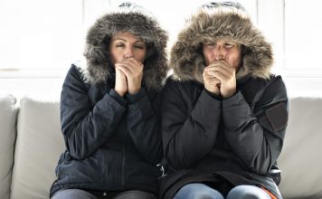 Couple, shivering cold, in home that has not heat during the chilly fall and winter