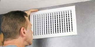 Man looks at HVAC vent